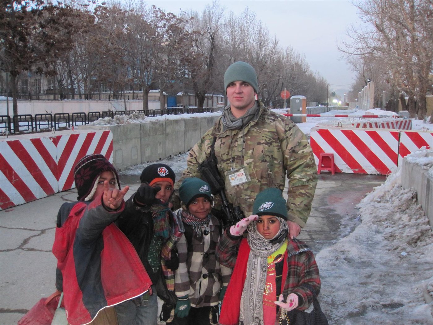 Johnathan Melin, U.S. Army veteran and now Idaho REALTOR® at Good News Realty Group, in multicam uniform with a group of Afghan children on a snowy Kabul street, Afghanistan, 2011 — Operation Enduring Freedom