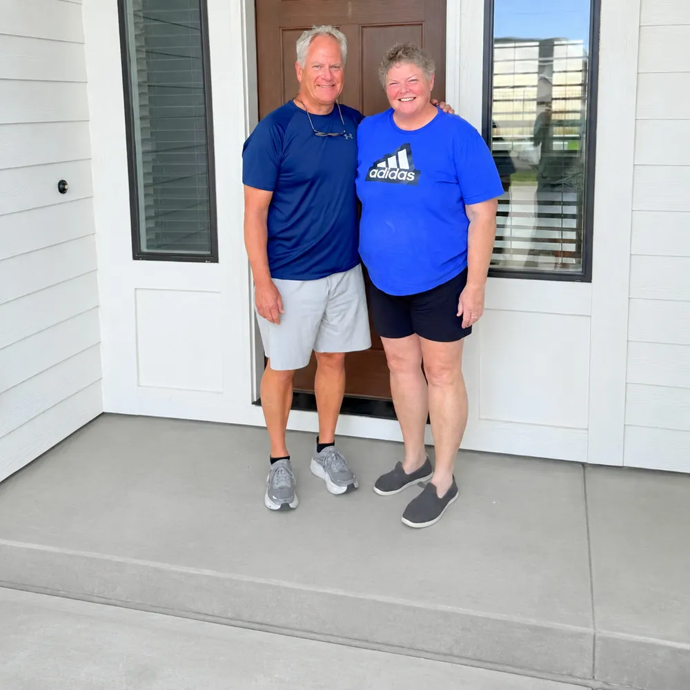 Two new homeowners standing at the front door of their home