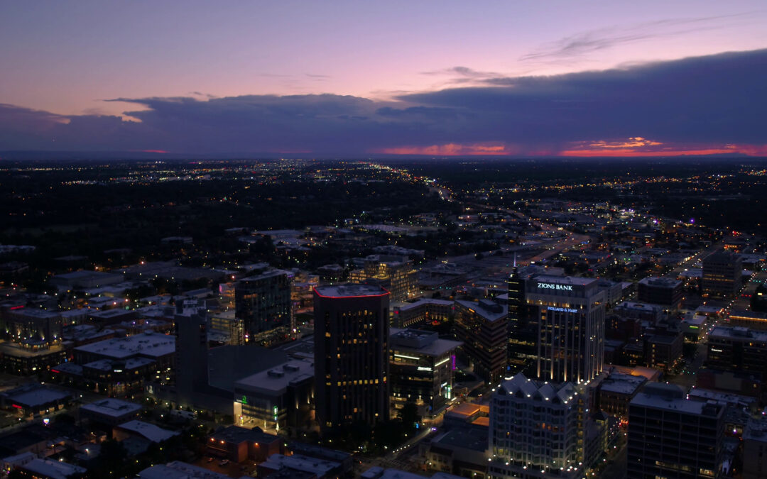 Downtown Boise, Idaho skyline at dusk with city lights and sunset clouds over the Treasure Valley