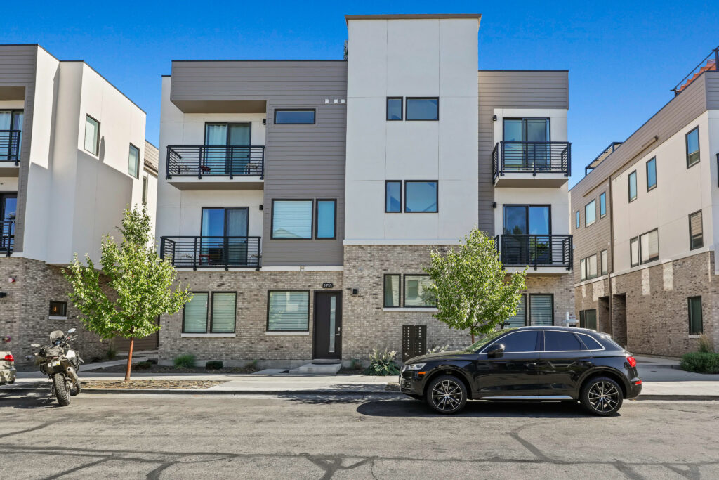 Exterior Front View – 2719 W Stewart Ave - Good News Realty Group Modern multi-story townhouse with brick and panel siding, black railing balconies, and a clean streetscape.