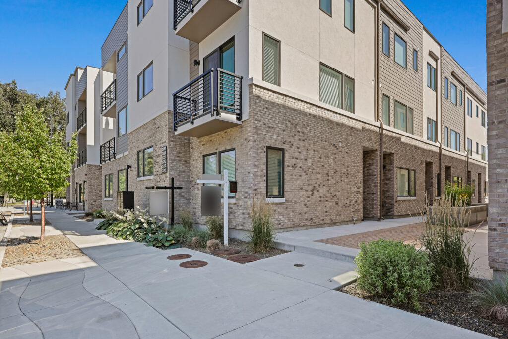 Sidewalk Entryway at 2719 W Stewart Ave - Good News Realty Group Walkway with landscaping and real estate signs leading to the front of a townhome complex.